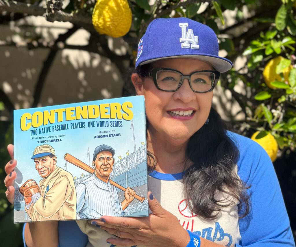 Arigon Starr holds the book Contenders.